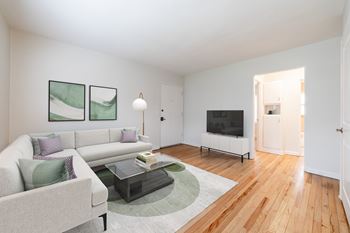 Bright living room at Monon Court Apartments in Broad Ripple featuring hardwood floors, large windows, and spacious one- and two-bedroom layouts.